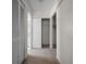 Hallway featuring three closets, neutral colored walls and carpet, and doors to the bathroom at 21425 Sw Plantation St, Dunnellon, FL 34431