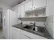 Modern kitchen features stainless sink, white appliances and backsplash, and granite countertop at 21425 Sw Plantation St, Dunnellon, FL 34431