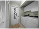 Practical laundry room featuring washer, dryer, utility cabinets, and door that has HOME spelled vertically at 21425 Sw Plantation St, Dunnellon, FL 34431