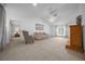 Open living room with fireplace, carpet, fan, and vaulted ceiling at 21425 Sw Plantation St, Dunnellon, FL 34431