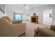 Inviting living room with fireplace, ceiling fan, light colored carpet, and neutral colored furniture at 21425 Sw Plantation St, Dunnellon, FL 34431