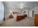 Spacious primary bedroom with a ceiling fan, carpet, and matching dressers and nightstands at 21425 Sw Plantation St, Dunnellon, FL 34431