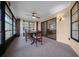 Enclosed sunroom with dining table, fan and carpeting at 21425 Sw Plantation St, Dunnellon, FL 34431