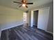 Bedroom with dark gray wood floors with a large double closet and a view to the kitchen at 235 Locust Pass Ln, Ocala, FL 34472
