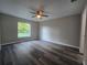 Bedroom featuring a ceiling fan, window, and grey walls over modern flooring at 235 Locust Pass Ln, Ocala, FL 34472