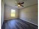Bright bedroom featuring dark wood laminate floors, a ceiling fan, and a window at 235 Locust Pass Ln, Ocala, FL 34472