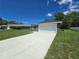 Exterior showcasing the driveway, two-car garage, and landscaped front yard at 235 Locust Pass Ln, Ocala, FL 34472