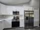 Kitchen featuring white cabinets, stainless steel appliances, and a microwave over the range at 235 Locust Pass Ln, Ocala, FL 34472