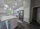 Open kitchen with white cabinetry, a stainless steel refrigerator, and an island with marble countertop at 235 Locust Pass Ln, Ocala, FL 34472