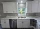 Modern kitchen featuring white cabinets, stainless steel appliances, and marble countertops at 235 Locust Pass Ln, Ocala, FL 34472