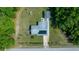 Birds eye view of a single-Gathering home featuring a gray roof and solar panels, surrounded by green grass and mature trees at 23737 Nw Mallard Ave, Dunnellon, FL 34431