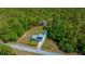An aerial view of the property showing the house, storage shed, and forest at 23737 Nw Mallard Ave, Dunnellon, FL 34431