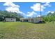 Backyard featuring a white detached building and the rear of the home with lush grass at 23737 Nw Mallard Ave, Dunnellon, FL 34431