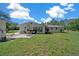 Backyard showcasing a covered patio area with outdoor furniture and an adjacent detached building at 23737 Nw Mallard Ave, Dunnellon, FL 34431