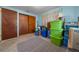 This bedroom boasts a neutral carpet, and sliding closet with storage containers, and bright blue walls at 23737 Nw Mallard Ave, Dunnellon, FL 34431