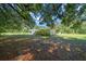 Exterior view of the house, showcasing yard and siding under a canopy of trees at 23737 Nw Mallard Ave, Dunnellon, FL 34431