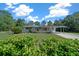 Exterior of a single-story home featuring mature landscaping and a well-maintained lawn at 23737 Nw Mallard Ave, Dunnellon, FL 34431