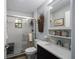 Bathroom featuring a glass shower, dark vanity with sink, decorative mirror, and neutral paint at 3250 Sw 46Th Ave, Ocala, FL 34474