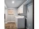 Clean laundry room features a side-by-side washer and dryer, overhead cabinets, and decorative 'Laundry Room' sign at 3250 Sw 46Th Ave, Ocala, FL 34474