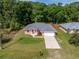 Aerial view of a one-story home with a 2-car garage, surrounded by a green lawn and trees at 3792 Sw 152Nd Ct, Ocala, FL 34481