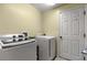 Modern laundry room features a washer, dryer, and convenient access to a door at 3792 Sw 152Nd Ct, Ocala, FL 34481