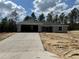 New construction featuring a concrete driveway, gray exterior paint, and dark gray roof at 4374 Sw Viola Ct, Dunnellon, FL 34431