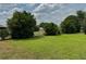 Spacious backyard featuring a well-manicured lawn, mature trees, and partial fencing at 4513 Nw 30Th Pl, Ocala, FL 34482