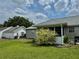 Backyard view showing the home's exterior, grassy lawn, mature landscaping, and detached garage at 4513 Nw 30Th Pl, Ocala, FL 34482
