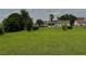 A lush, green lawn surrounds the property, enhanced by mature trees and partial fencing at 4513 Nw 30Th Pl, Ocala, FL 34482