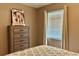 Bright bedroom featuring a wooden dresser, window with blinds, and decorative artwork at 4513 Nw 30Th Pl, Ocala, FL 34482