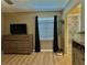 Bedroom featuring a large window with black curtains, an organized wood dresser and open doorway to the bathroom at 4513 Nw 30Th Pl, Ocala, FL 34482