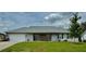 Charming single-story home with a well-manicured lawn, gray roof, and inviting front porch at 4513 Nw 30Th Pl, Ocala, FL 34482
