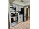 Updated kitchen with stainless steel appliances, gray cabinetry, modern hardware, and wood-look flooring at 4513 Nw 30Th Pl, Ocala, FL 34482