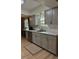 Bright kitchen featuring a stainless steel dishwasher and sink, light gray cabinets, and white hexagon tile backsplash at 4513 Nw 30Th Pl, Ocala, FL 34482