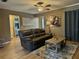 Comfortable living room with a leather couch, wood floors, ceiling fan, and neutral color scheme at 4513 Nw 30Th Pl, Ocala, FL 34482