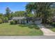 Charming single-story home with a well-maintained lawn and mature trees under a clear blue sky at 511 Se 29Th Ter, Ocala, FL 34471