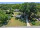 Landscaped front yard with mature trees leading to a charming single-story home, complemented by a well-maintained lawn and driveway at 511 Se 29Th Ter, Ocala, FL 34471