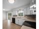 Updated kitchen with white cabinets, modern backsplash, stainless steel appliances and wood-look tile flooring at 511 Se 29Th Ter, Ocala, FL 34471
