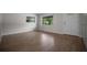 Inviting living room with wood-look tile flooring, white walls and natural light at 511 Se 29Th Ter, Ocala, FL 34471