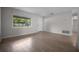Bright living room with wood-look tile flooring, white walls and a large window at 511 Se 29Th Ter, Ocala, FL 34471