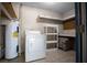 Utility room features a washer, dryer, water heater, shelving, and peg board for storage at 511 Se 29Th Ter, Ocala, FL 34471