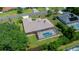 An aerial shot showcases a home with a screened-in pool, lush greenery, and a well-manicured lawn, perfect for outdoor enjoyment at 5420 Sw 86Th Ln, Ocala, FL 34476
