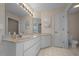 Bathroom featuring dual sinks, expansive vanity, and a separate toilet area at 5420 Sw 86Th Ln, Ocala, FL 34476