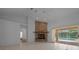 Bright living room with tiled flooring, brick fireplace, and large sliding glass doors to a screened-in pool at 5420 Sw 86Th Ln, Ocala, FL 34476