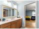 Bathroom with wood cabinet, countertop, and a view into the bedroom at 6045 Se 99Th Pl, Belleview, FL 34420