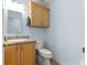 Bathroom with wooden cabinets, granite countertop, and updated fixtures at 6045 Se 99Th Pl, Belleview, FL 34420