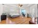 Bright bedroom with wood floors, a tray ceiling, a ceiling fan, and an abundance of natural light at 6045 Se 99Th Pl, Belleview, FL 34420