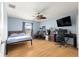 Bedroom with wooden flooring, ceiling fan, blue walls, and furniture at 6045 Se 99Th Pl, Belleview, FL 34420