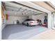 Spacious garage featuring epoxy floors, washer, dryer and parked car at 6045 Se 99Th Pl, Belleview, FL 34420