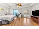 A spacious main bedroom features wood floors, ceiling fan, and French doors leading to the pool at 6045 Se 99Th Pl, Belleview, FL 34420